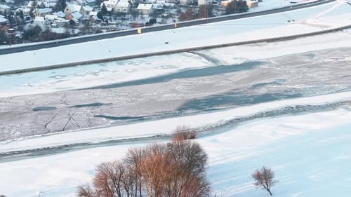 Luftaufnahme eines gefrorenen Flusses inmitten einer ruhigen Winterlandschaft