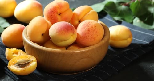 Fresh apricots in bowl with fruit, harvest concept