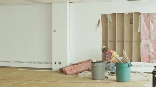Construction worker tiding debris from office space in Canada building renovation