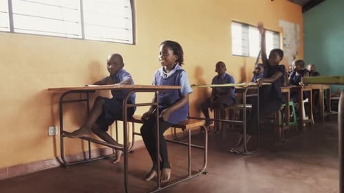 Front View of African Pupils / Students Raising Hand in Class