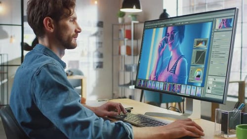Male Digital Editor in Jeans Shirt Works in Image Editing Software on His Personal Computer with Bi