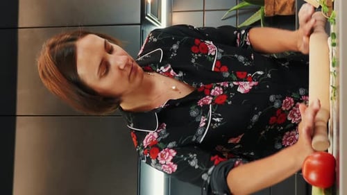 Woman rolling dough in kitchen