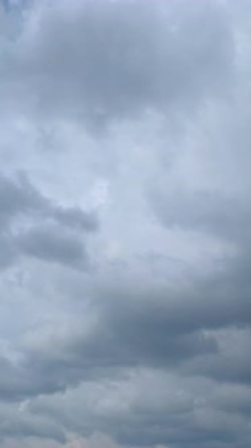 Fluffy White Clouds Drifting Across Blue Sky