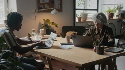 Fille avec bras prothétique travaillant sur un ordinateur portable dans un bureau confortable