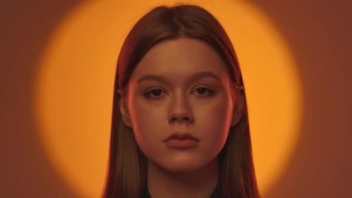 Elegantes Portrait einer Frau mit Dramatisch orangefarbener Hintergrundbeleuchtung