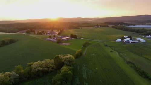 Hilly agricultural farm fields during golden Sunset in America. Aerial lateral wide shot. Calm and p