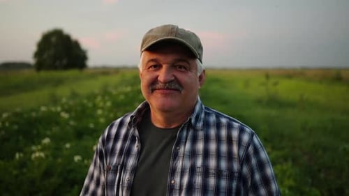 Friendly Farmer Standing in Field at Sunset
