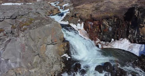 Die Kamera schwenkte majestätisch über den kaskadierenden Schleier des Wasserfalls und enthüllte den komplizierten Tanz