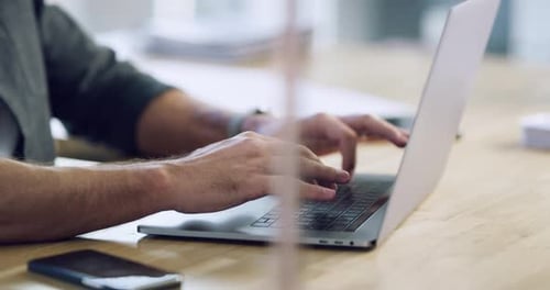 4k video footage of an unrecognizable businessman typing on a laptop while working in his office