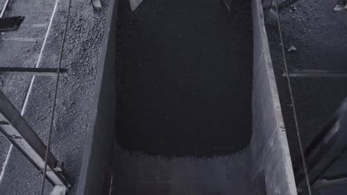 Pouring Iron Coal On Freight Wagon In The Railway. - high angle