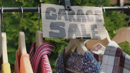 Garage Sale Used Clothing for Sale Hanging on a Rack Outdoors