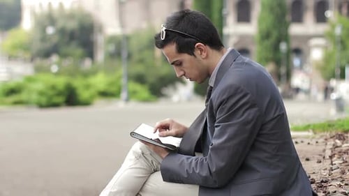Business man using digital tablet at park