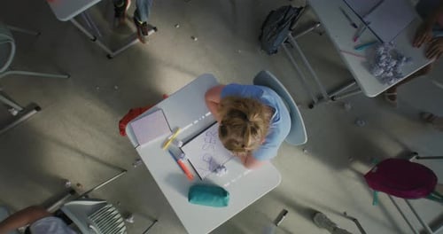 Depressed Primary School Girl Sitting Alone at Desk While Aggressive Classmates Abusing Her