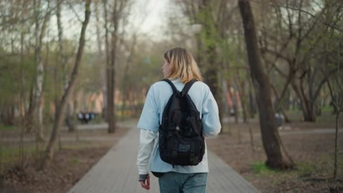 Quiet Journey Past Trees Solitary Traveler in Springtime Woodland Silent Pedestrian in Spring Hues