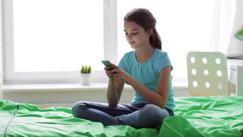 Teen Girl Using Smartphone on Bed in Bedroom