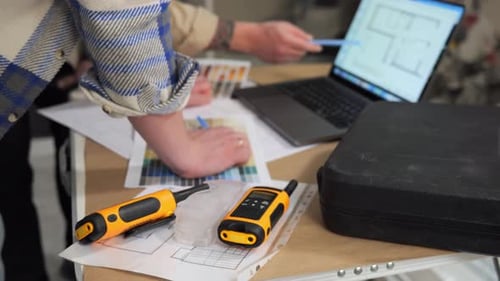 Two Yellow Walkietalkies are Lying on a Table at the Construction Site