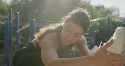 Young Woman Stretching Outdoors on a Sunny Day