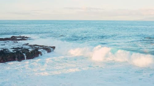 White splashes of water from the sea towards the rocks on the seashore in Tenerife, Spain, static cl