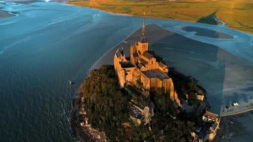 Aerial drone view of Mont-Saint-Michel at sunset in Normandy, France. Water of the English Channel