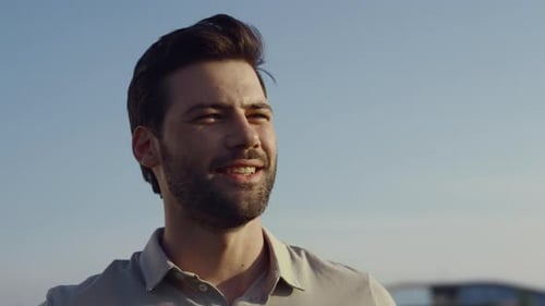 Handsome young man laughing enjoying summer holiday near the resort on a sunny day