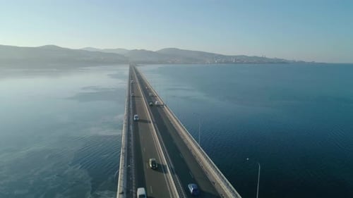 Drohnenaufnahme der Niedrigwasserbrücke über die Bucht mit fahrendem Auto und aktiver Transportbewegung