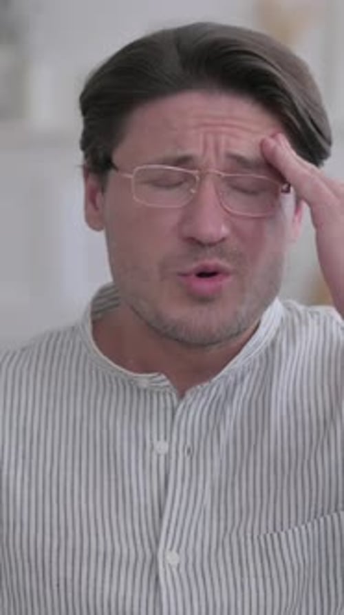 Portrait of Young Man having Headache at Home, Vertical Video