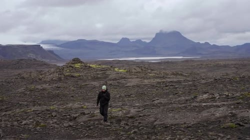 Man Walking Across Volcanic Landscape in Iceland