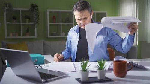 Home office worker throwing papers.