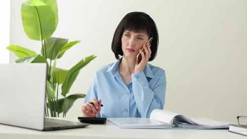 Woman Working at Desk with Mobile Phone