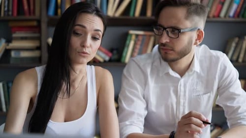 Two Students Brainstorming Work by Discuss with Desktop in Hipster Loft Closeup