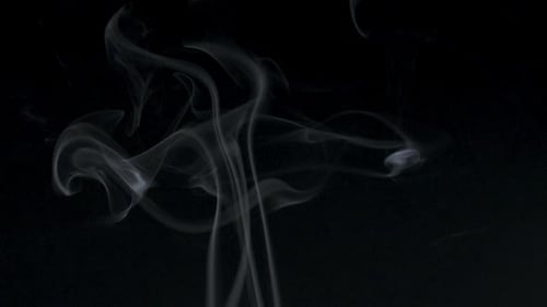 Wispy White Smoke Flowing Against Black Background
