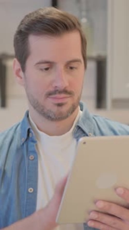 Portrait d'un jeune homme utilisant une tablette informatique, vidéo verticale