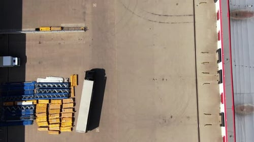 Semi-trailer trucks stand at the ramps of warehouse in the logistics park with loading hub and wait