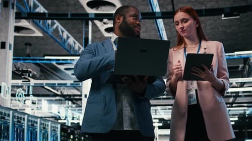 Data Center Team Examining Servers with Laptop, Tablet