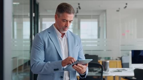 Mature Older Business Man Executive Using Digital Tablet Standing in Office