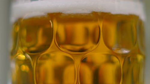 Pan Down Frisch gegossenes, gekühltes Bierlager in traditionellem Glas mit lebendiger oranger Farbe