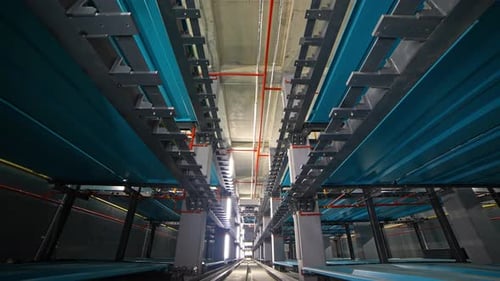 Central Transport Shuttle Moving a Vehicle Inside an Automated Robotic Parking System