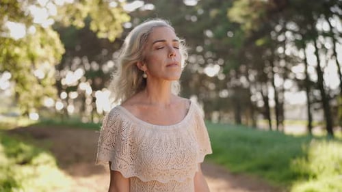 Senior Woman Taking Deep Breath in Nature Enjoying Peace and Fresh Air in the Forest