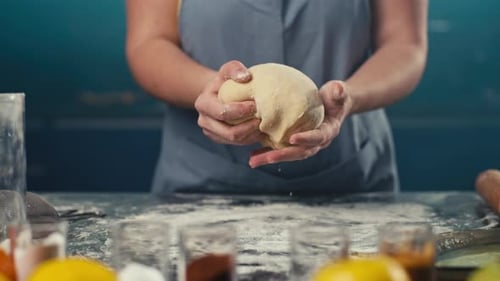 Woman Kneading Dough on Flour Covered Table