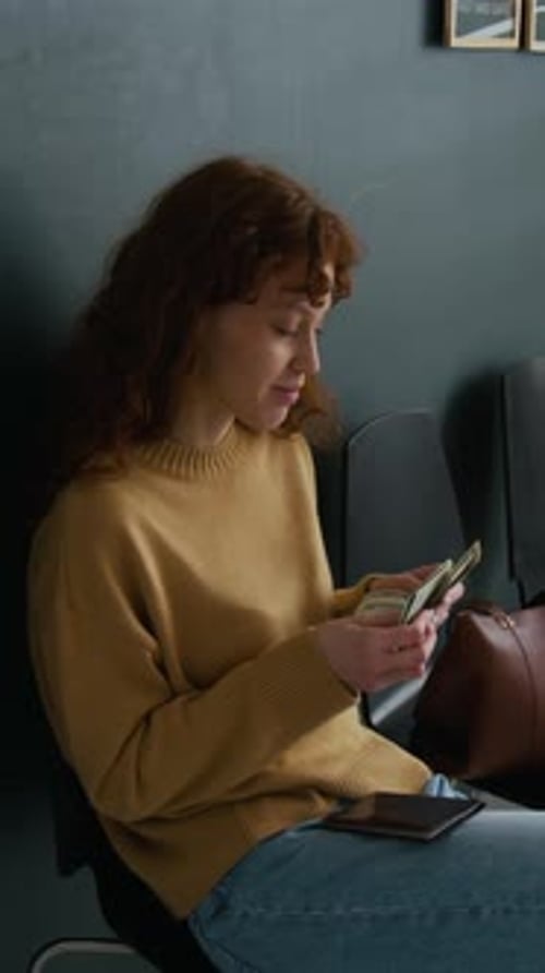 Woman Counting Cash While Waiting in Bank Office Queue