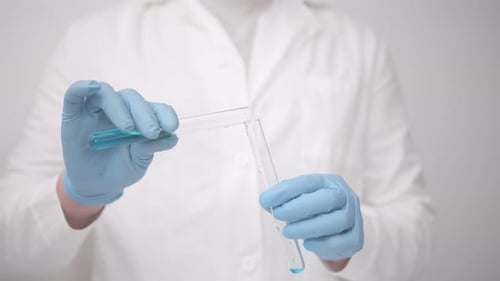 Scientist Pouring Blue Liquid into a Test Tube