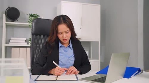 Frustrated Asian young businesswoman overwork late in office workplace.