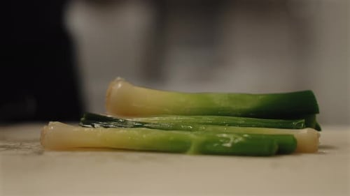 Extreme Slow Motion Close-Up of Green Onion Being Chopped Up