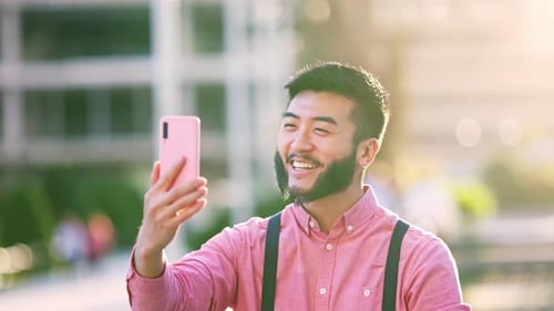 Happy Stylish Asian Man Doing a Video Call with the Mobile Outdoors in the City