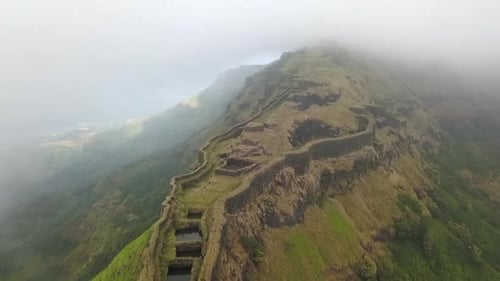 Vue aérienne du fort médiéval isolé de Torna perché au sommet d'une colline indienne à travers les nuages