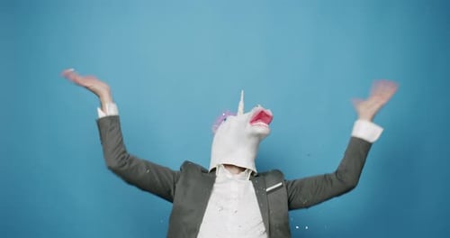Mann mit Einhornmaske macht lustige Gesten