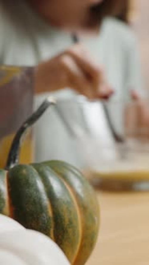 Vertical video. Ingredients for Pumpkin Cookies, Woman Kneading Dough, with Small Pumpkins.