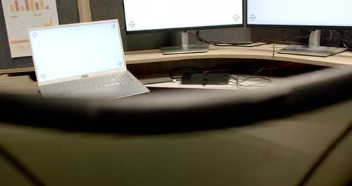 General view of laptop and computers with blank screens in office, slow motion