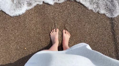 Looking Down at your Feet As you Walk Along the Golden Sand Beach Washed By Crystal Clear Sea Water