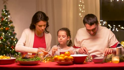 Family Eating Festive Dinner at Home During Christmas